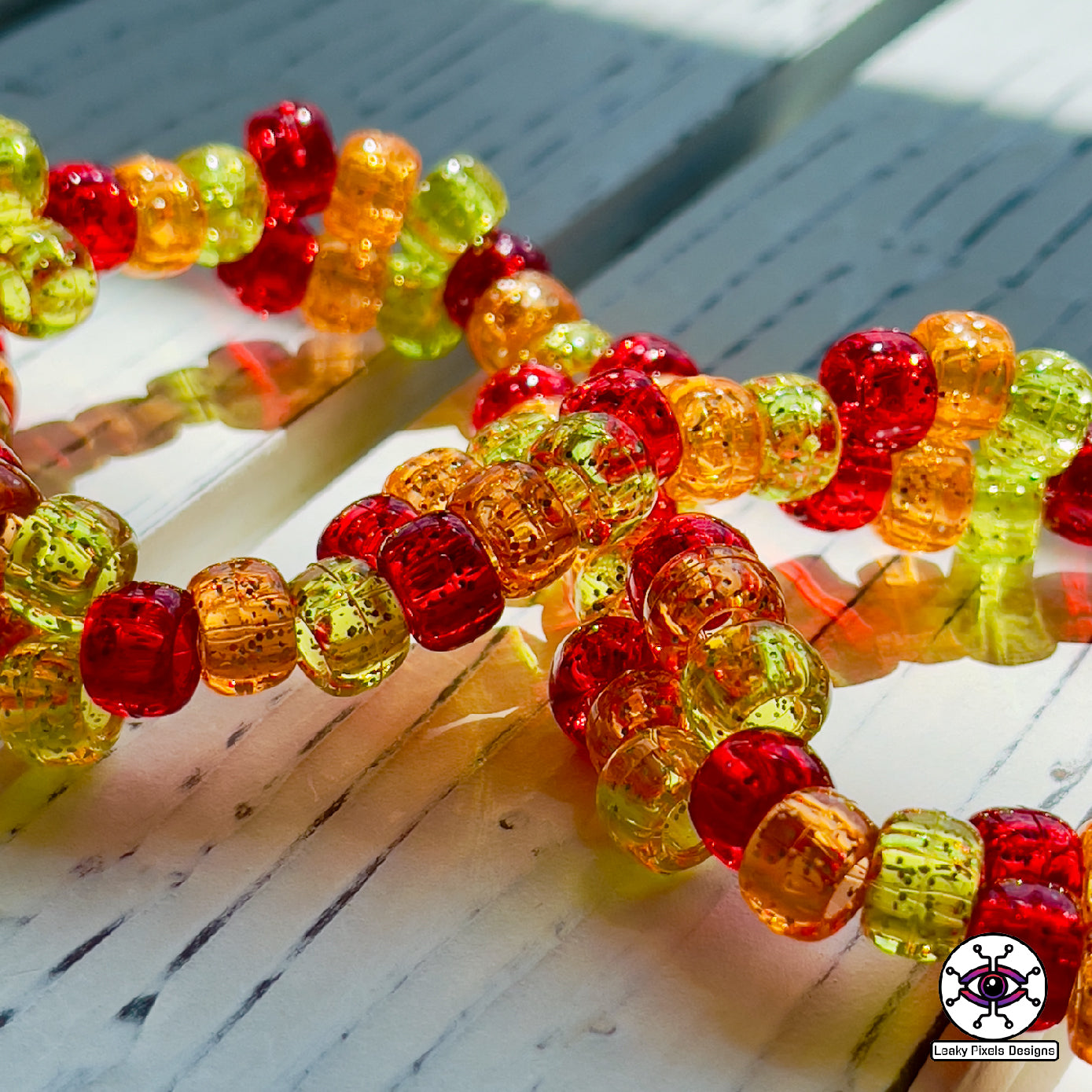 Flareon perler necklace, Orange and yellow pokemon that is dog like and fluffy. pointy ears also. necklace is made out of red, orange and yellow glitter pony beads