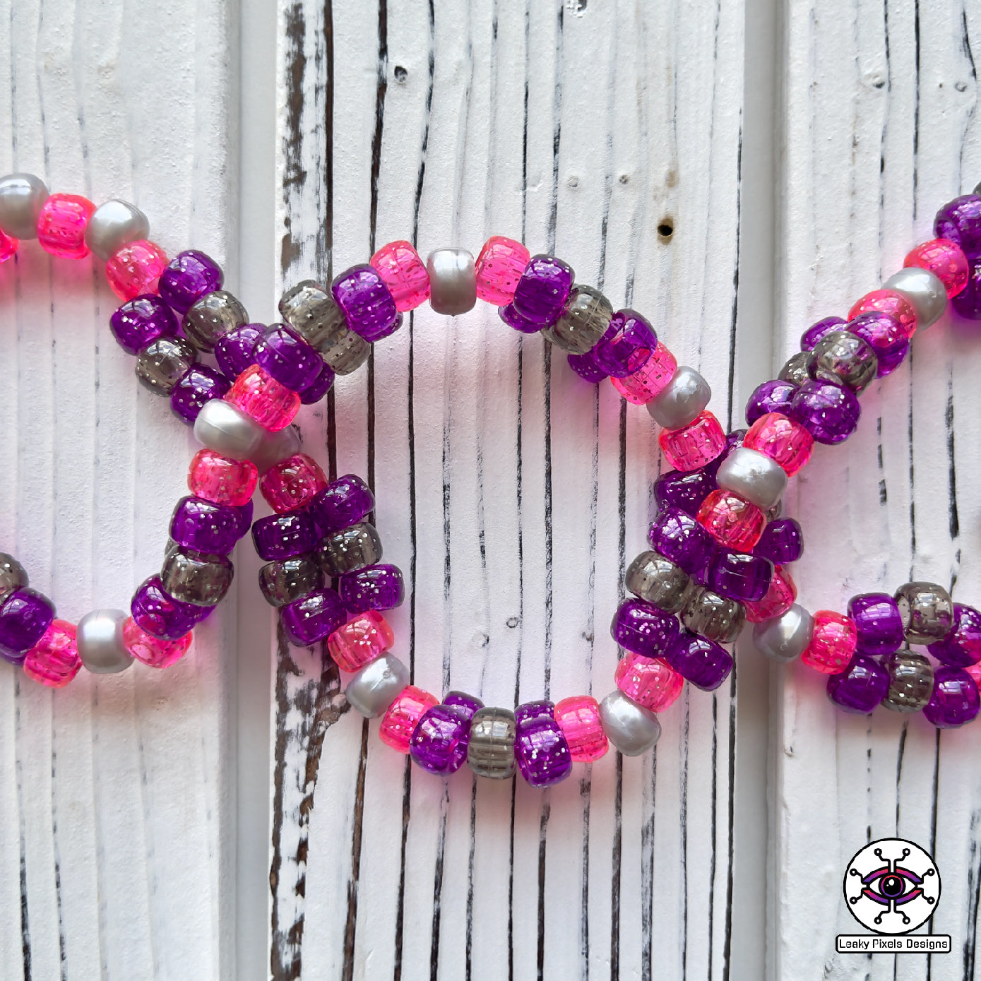 Gengar Subtronics Perler Necklace. Purple ghost pokemon that has a hypnotizing cyclops eye, sharp looking teeth and long pink tongue sticking out.