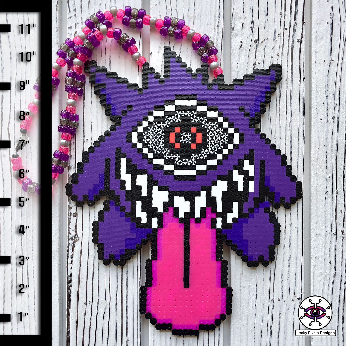 Gengar Subtronics Perler Necklace. Purple ghost pokemon that has a hypnotizing cyclops eye, sharp looking teeth and long pink tongue sticking out.