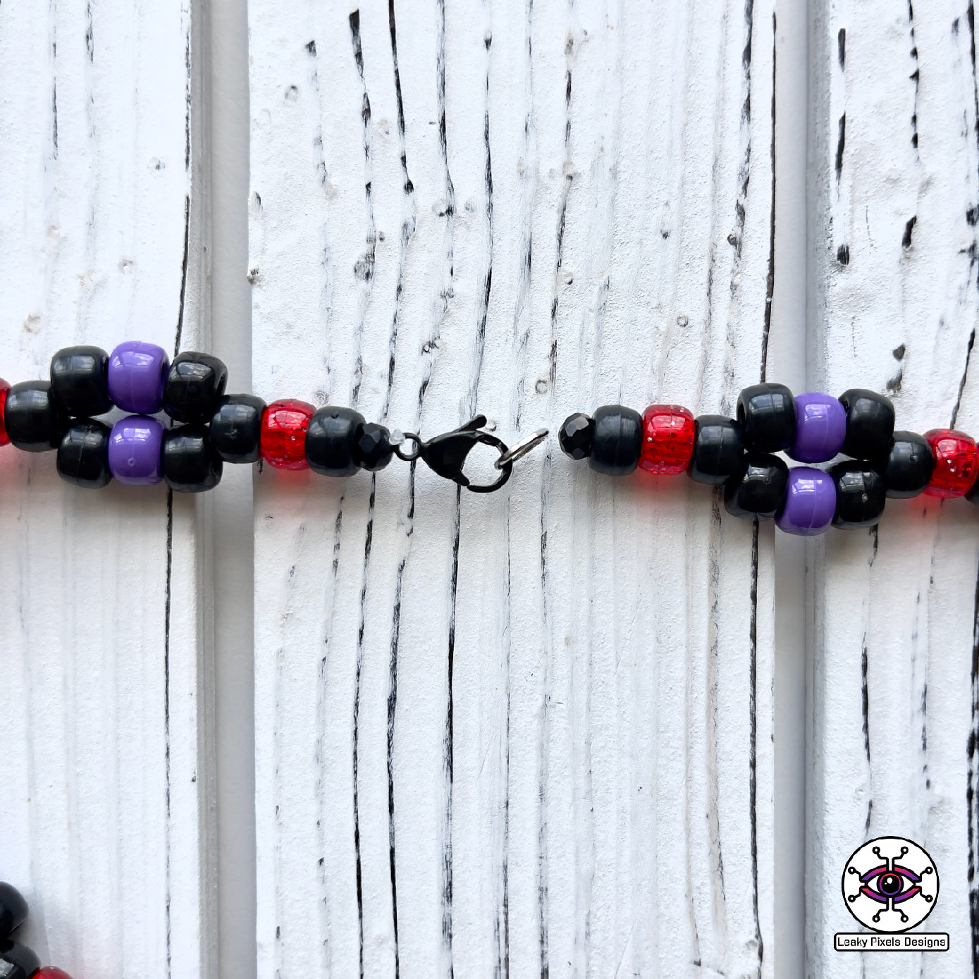 Dark purple kraken perler necklace with red eye and suckers. mysterious and dark. necklace is made of purple, black, red, silver and clear pony beads. high detail and quality.