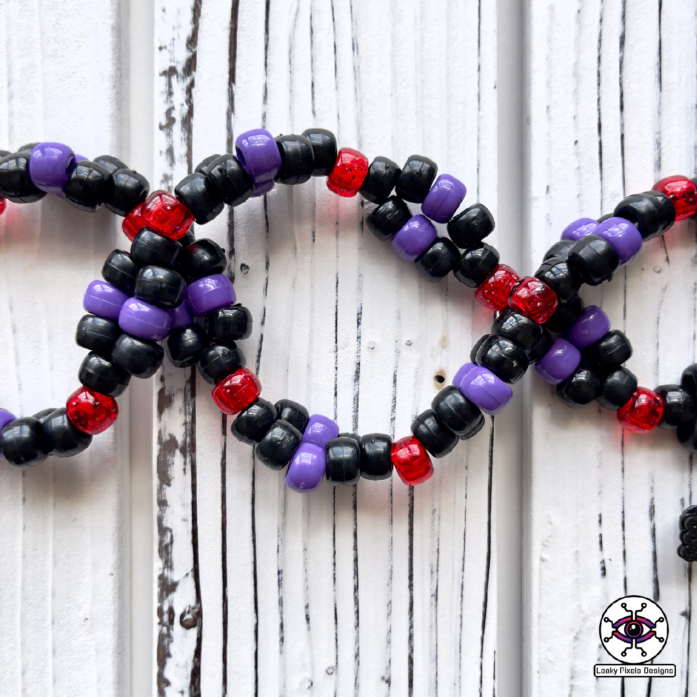 Dark purple kraken perler necklace with red eye and suckers. mysterious and dark. necklace is made of purple, black, red, silver and clear pony beads. high detail and quality.