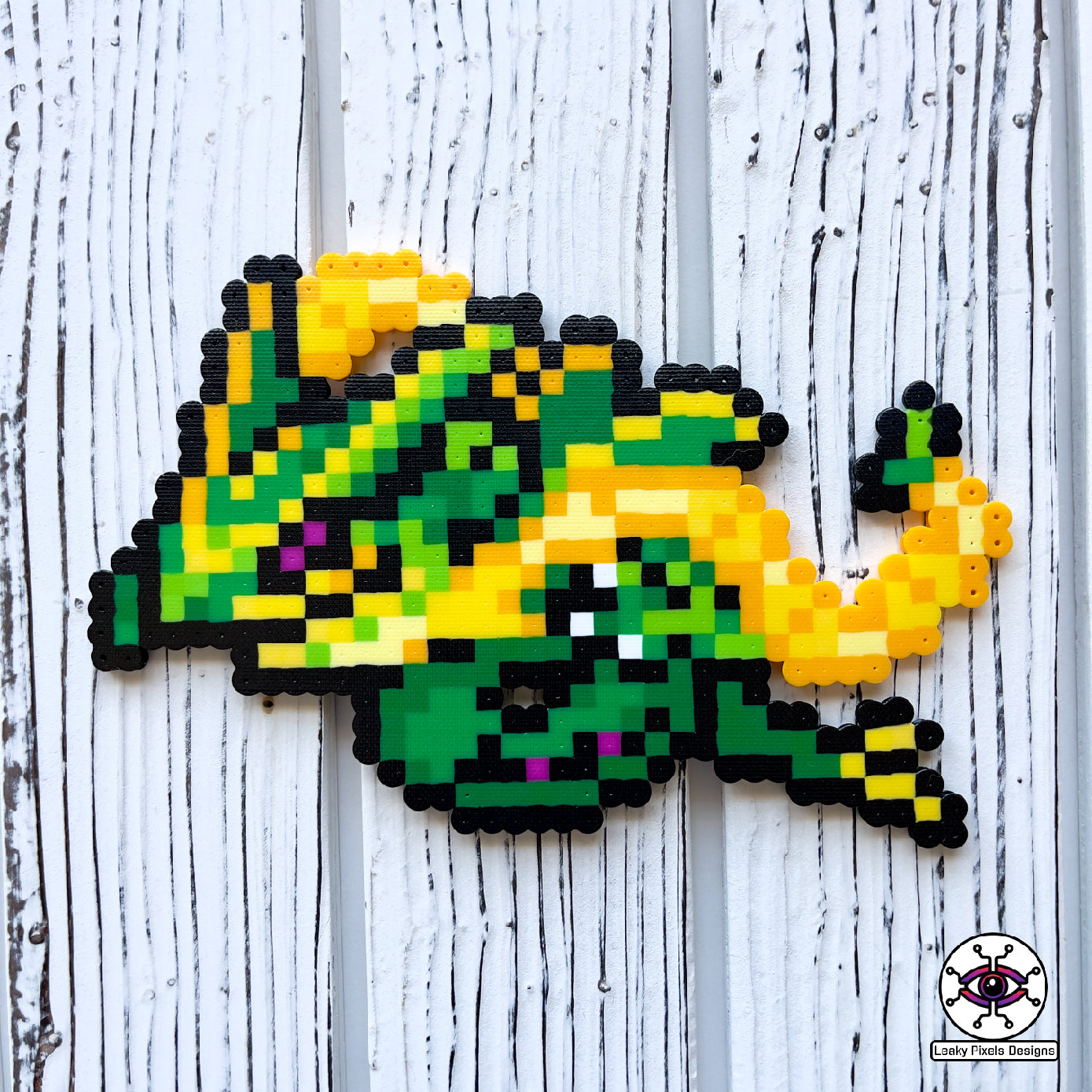 mega rayquaza pokemon perler necklace. green dragon with yellow and orange tendrils flying beside its body. pony beads make up the necklace.